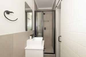 a bathroom with a white sink and a shower at Durbanville Daydream in Durbanville +33 photos