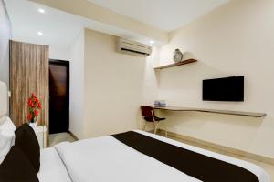 a bedroom with a bed and a tv on the wall at Townhouse Hotel Sec- 54 Golf Course Road in Gurgaon +23 photos