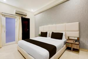 a bedroom with a large white bed and a window at Townhouse Hotel Sec- 54 Golf Course Road in Gurgaon
