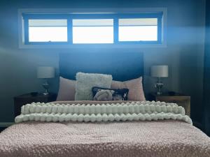 a bedroom with a large bed with two windows at The Sunset Deck in Beechworth