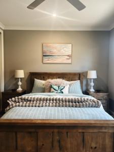 a bedroom with a large wooden bed with two lamps at The Sunset Deck in Beechworth +16 photos