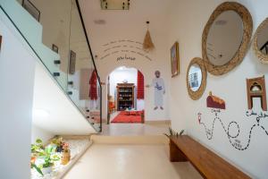 a hallway of a house with a staircase and mirrors at Bait mutirah guesthouse in Muscat