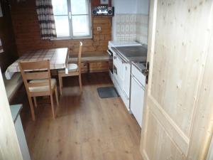 een kleine keuken met een tafel en een tafel en een tafel bij Almhütte Egger Obheimat in Außervillgraten +10 foto's