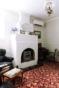 a living room with a fireplace and a couch at Miss Lucy Historic & Central in Beechworth