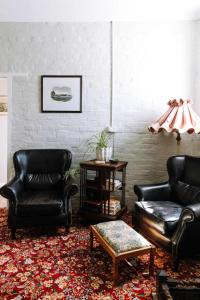 a living room with two leather chairs and a table at Miss Lucy Historic & Central in Beechworth