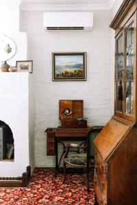 an old desk and chair in a room with a table at Miss Lucy Historic & Central in Beechworth