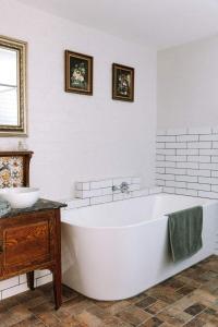 a white bathroom with a tub and a sink at Miss Lucy Historic & Central in Beechworth +11 photos