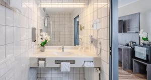 a bathroom with a sink and a mirror at PLAZA INN Grevenbroich in Grevenbroich