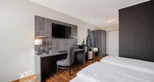 a hotel room with a desk and a bed at PLAZA INN Grevenbroich in Grevenbroich