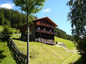 een blokhut op een heuvel in een veld bij Almhütte Egger Obheimat in Außervillgraten