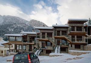 un edificio con un coche aparcado delante de él en la nieve en Chalet Christantoni, en Elati