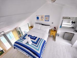 a bedroom with a bed with a blue and white striped blanket at Tiny float home Brighton in Brighton & Hove