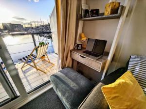 a small room with a laptop on a desk with a balcony at Tiny float home Brighton in Brighton & Hove