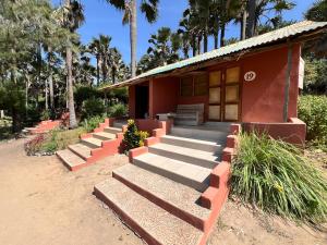 a small red building with steps leading up to it at Nemasu Eco-lodge in Gunjur