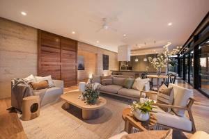 a living room with couches and tables and a kitchen at The Meldrum in Beechworth