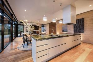 a kitchen with a large counter and a dining room at The Meldrum in Beechworth +42 photos