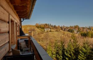 a balcony with chairs and a view of a town at Willa na Kozińcu Luxury Residence & SPA with Mountain View Zakopane in Zakopane