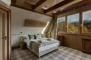 a bedroom with a bed and a large window at Willa na Kozińcu Luxury Residence & SPA with Mountain View Zakopane in Zakopane