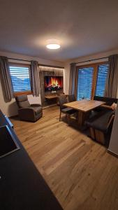 a living room with a table and a fireplace at Apart s'Peintl in Obertilliach