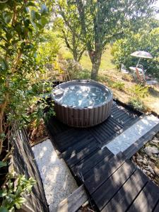 a hot tub sitting on top of a wooden deck at Rials in Aleyrac