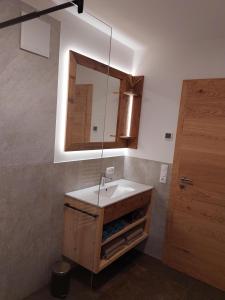 a bathroom with a sink and a mirror at Apart s'Peintl in Obertilliach +31 photos