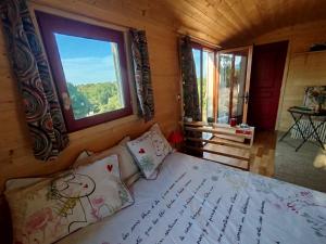 a bedroom with a bed with a large window at Rials in Aleyrac