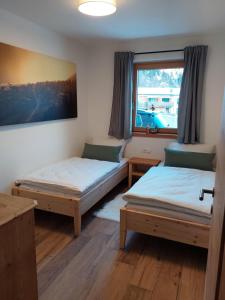 a room with two beds and a window at Apart s'Peintl in Obertilliach