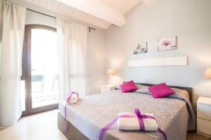 a bedroom with a large bed with pink pillows at Villa Cielo- Cignella Resort Tuscany Accommodation in Osteria Delle Noci