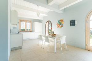 a kitchen and dining room with a white table and chairs at Villa Cielo- Cignella Resort Tuscany Accommodation in Osteria Delle Noci