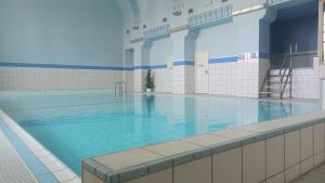 a large swimming pool with blue water in a building at Apartmány SRC in Nové Město pod Smrkem
