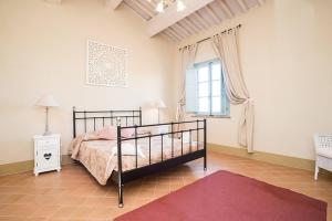a bedroom with a bed and a window at Quercia Apartment - Cignella Resort Tuscany in Osteria Delle Noci