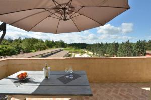 a table with an umbrella and a bottle of wine at Quercia Apartment - Cignella Resort Tuscany in Osteria Delle Noci