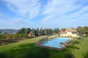 an estate with a swimming pool in a green field at Quercia Apartment - Cignella Resort Tuscany in Osteria Delle Noci
