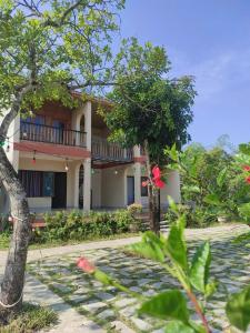 a house with a balcony on the side of it at Cat Tien Riverside Lodge in Tân Phú