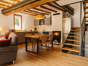 a kitchen and living room with a table and a fireplace at Casa espaiosa amb llar de foc in Ribes de Freser