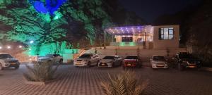a group of cars parked in front of a house at night at Dareen Resort in Bahlāʼ