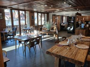 a restaurant with wooden tables and chairs and windows at hotel le malgovert SEEZ 73 in Séez