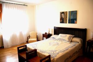a bedroom with a bed and a chair at Apartament Ca l'Emilia in Sedo