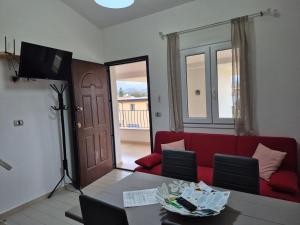 a living room with a red couch and a table at Casa Elias in Orosei