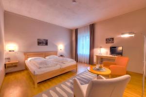 a bedroom with a bed and a table and chairs at Golfhotel Fahrenbach in Tröstau +37 photos
