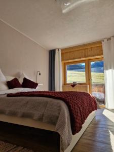 a bedroom with a bed and a large window at Apartment Neunerköpfle in Tannheim
