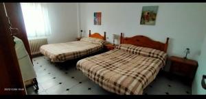 a bedroom with two beds and a tiled floor at Refugio Ruta Río Borosa in Coto Ríos