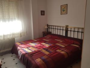 a bedroom with a bed with a colorful quilt on it at Refugio Ruta Río Borosa in Coto Ríos