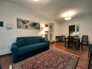 a living room with a blue couch and a dining room at Il Cortile delle magnolie in Gubbio
