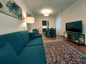 a living room with a blue couch and a flat screen tv at Il Cortile delle magnolie in Gubbio