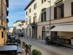 an empty street with buildings and tables and chairs at Il Cortile delle magnolie in Gubbio