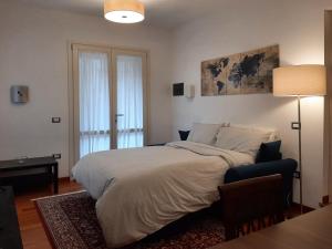 a bedroom with a bed and a table and a lamp at Il Cortile delle magnolie in Gubbio