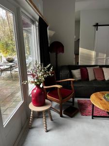 a living room with a couch and a vase with flowers at Bonte Specht in Otterlo
