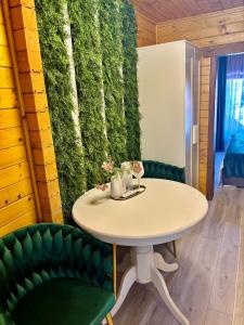 a green wall with a table and two green chairs at Rustic Baia Sprie in Baia-Sprie