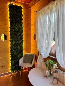 a room with a green wall with a chair and a table at Rustic Baia Sprie in Baia-Sprie